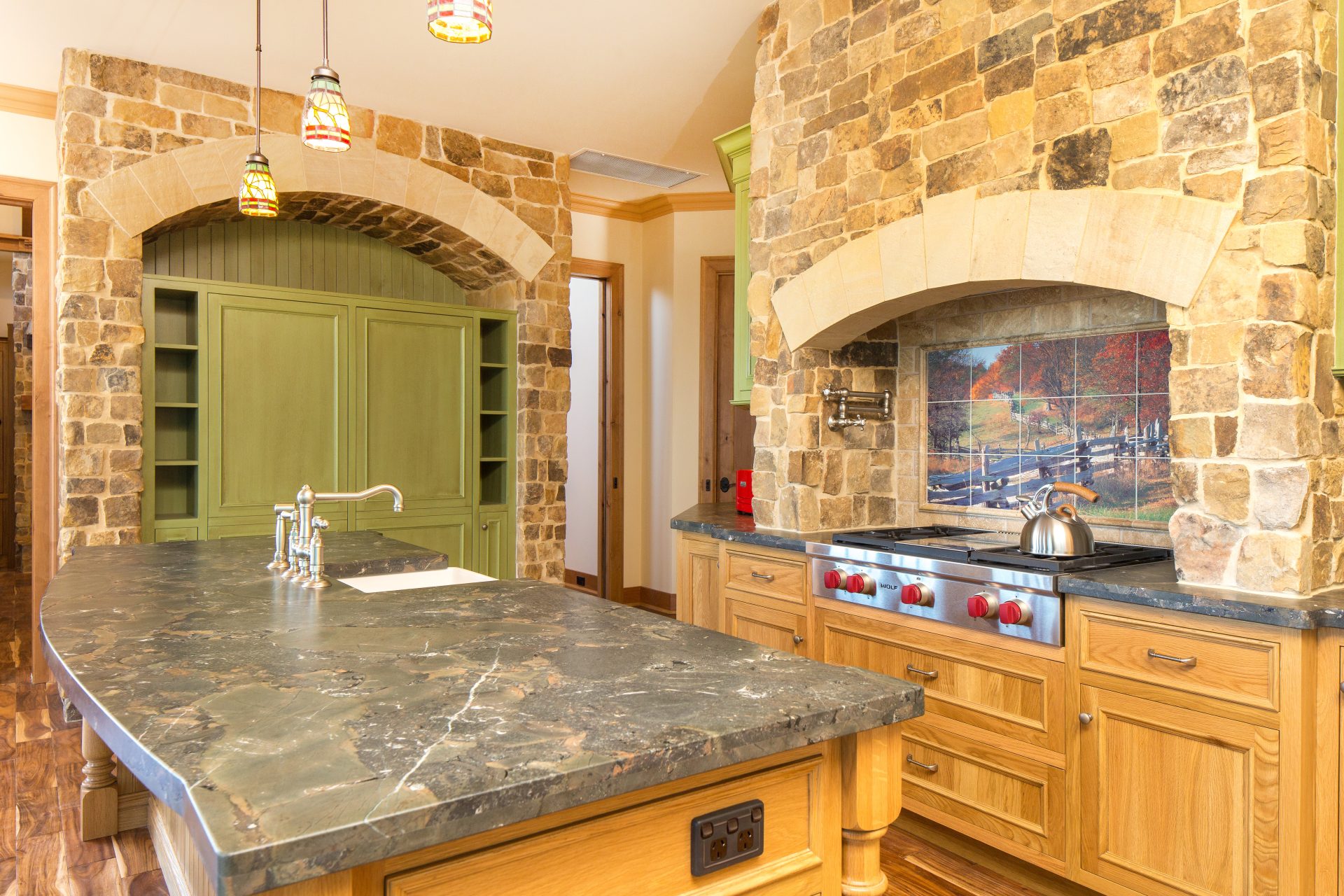 Award-winning American-style stone kitchen with custom timber joinery, arched stone surrounds and farmhouse detailing.