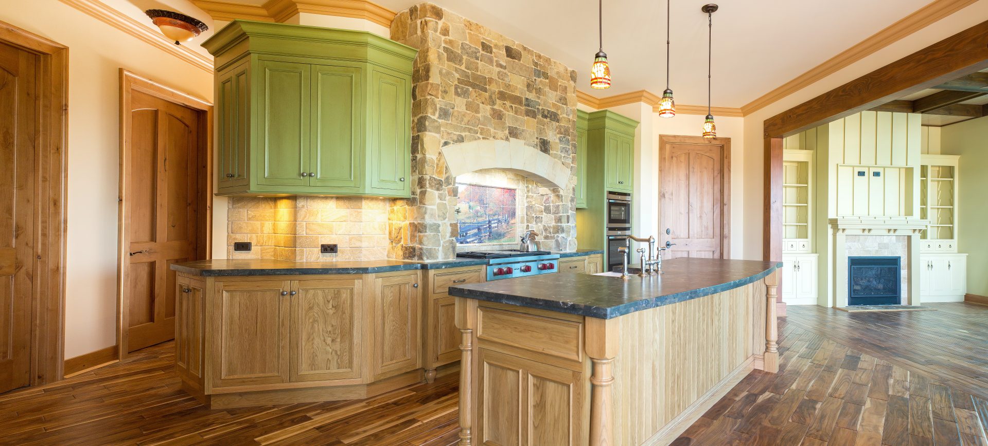Award-winning American-style stone kitchen with custom timber joinery, arched stone surrounds and farmhouse detailing.