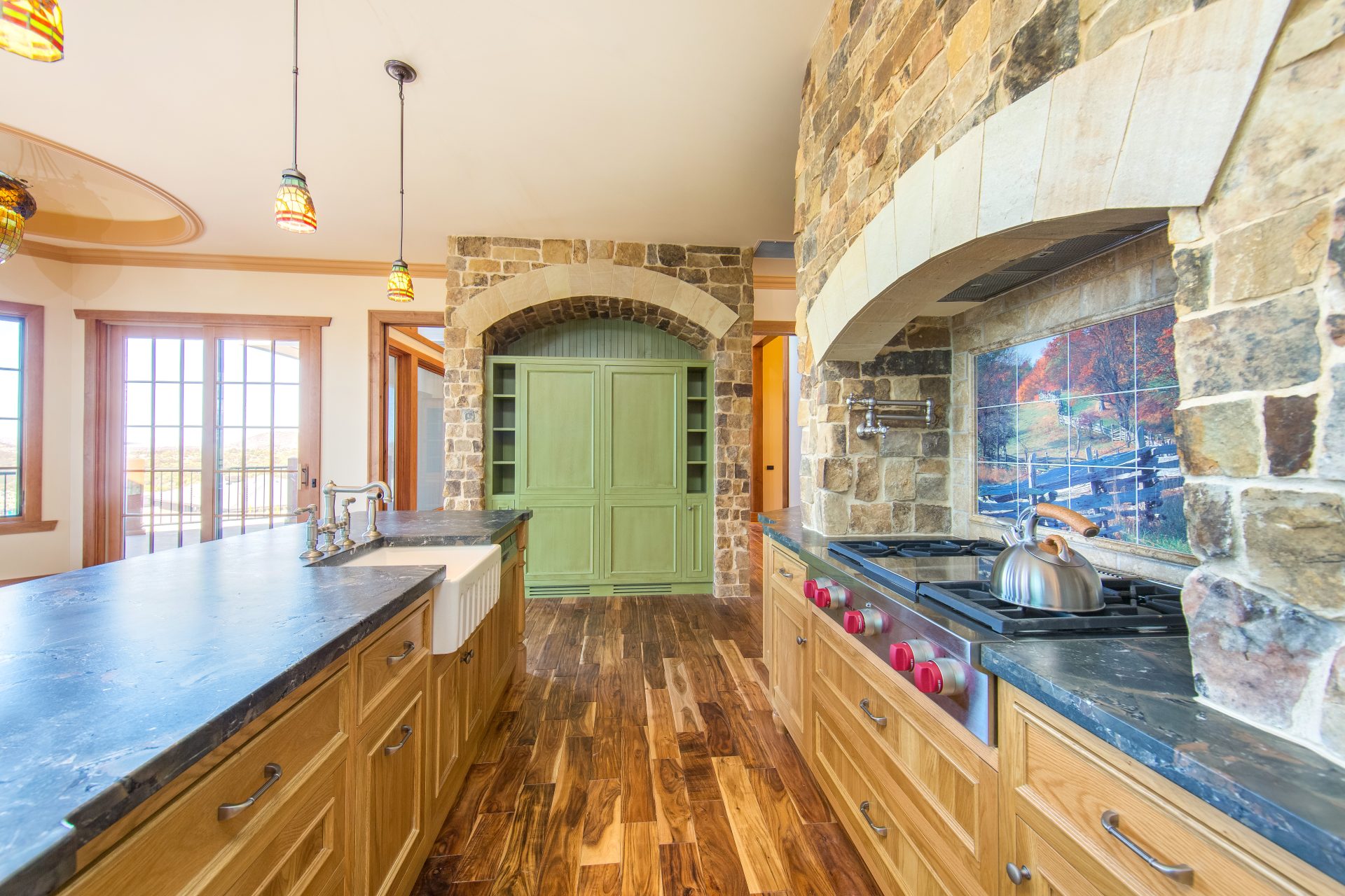 Award-winning American-style stone kitchen with custom timber joinery, arched stone surrounds and farmhouse detailing.
