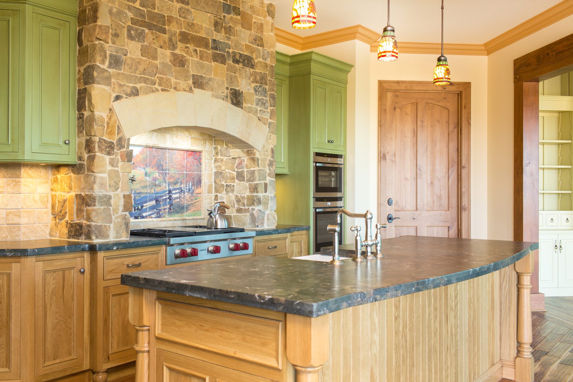 Award-winning American-style stone kitchen with custom timber joinery, arched stone surrounds and farmhouse detailing.