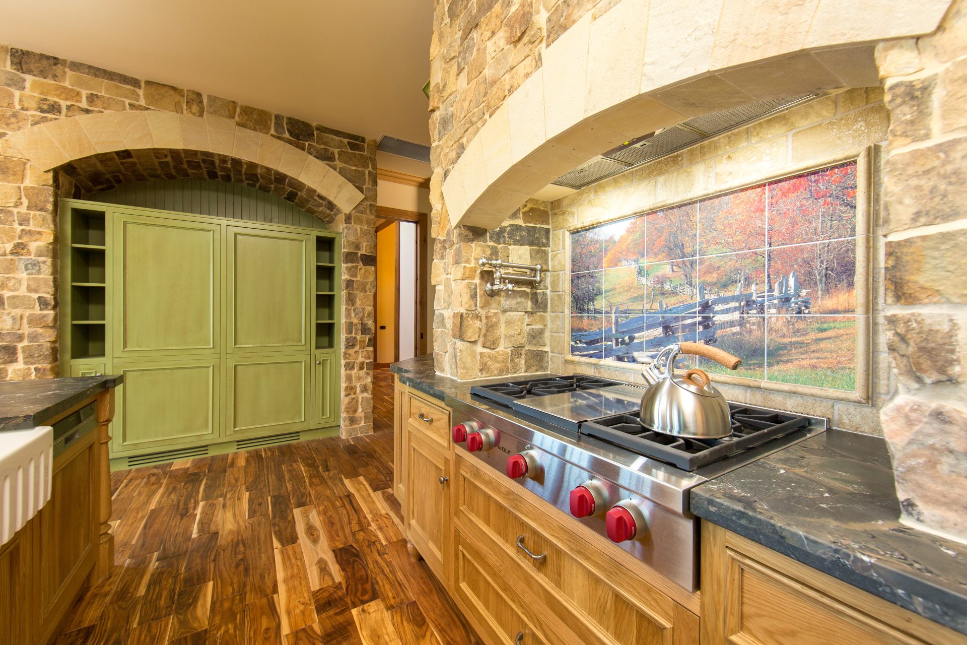 Award-winning American-style stone kitchen with custom timber joinery, arched stone surrounds and farmhouse detailing.